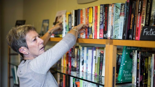 A woman takes a book from a shelf at Chartwell in Kent